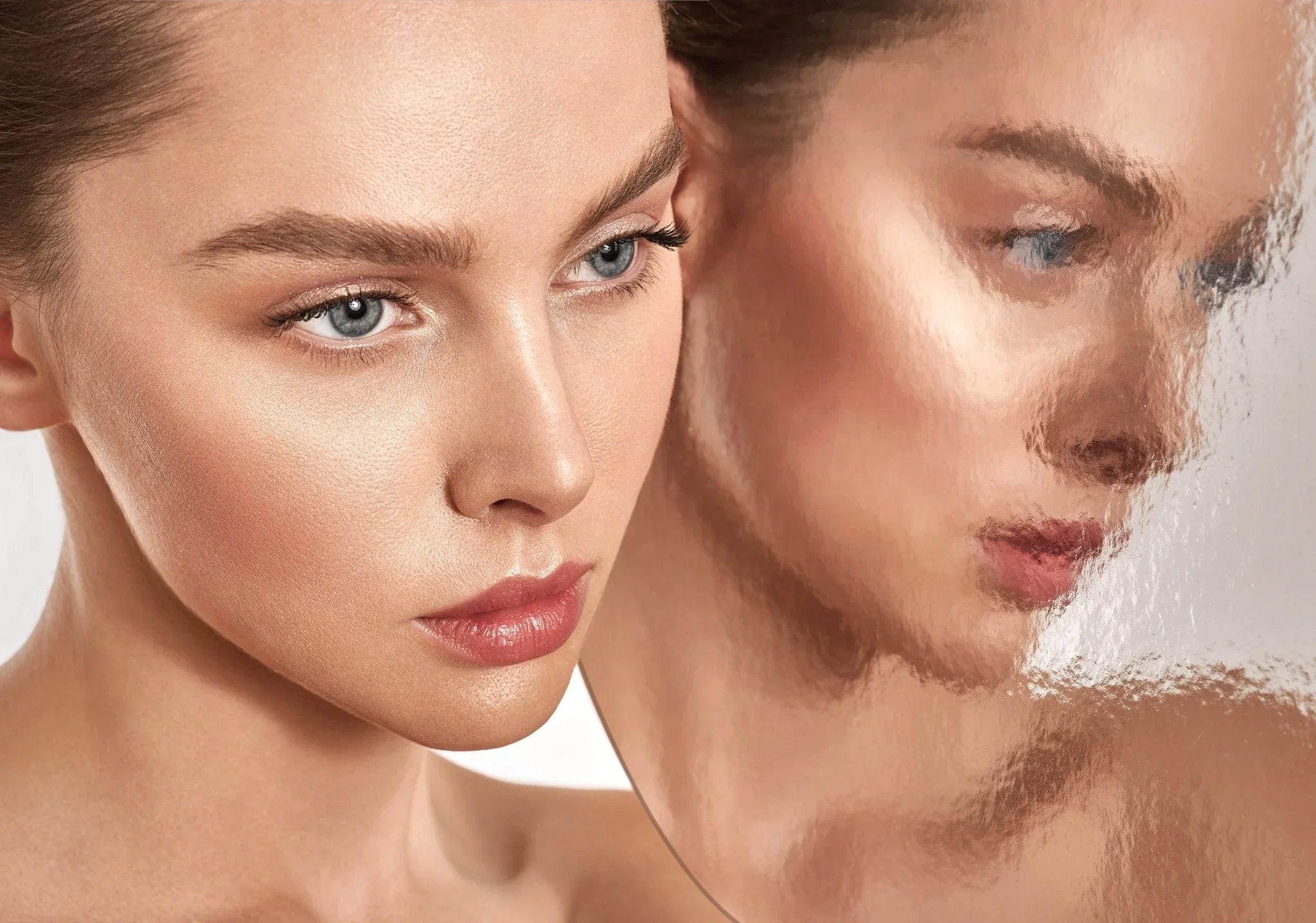 Femme au teint lumineux et naturel se regardant dans un miroir flou, soins beauté vegan