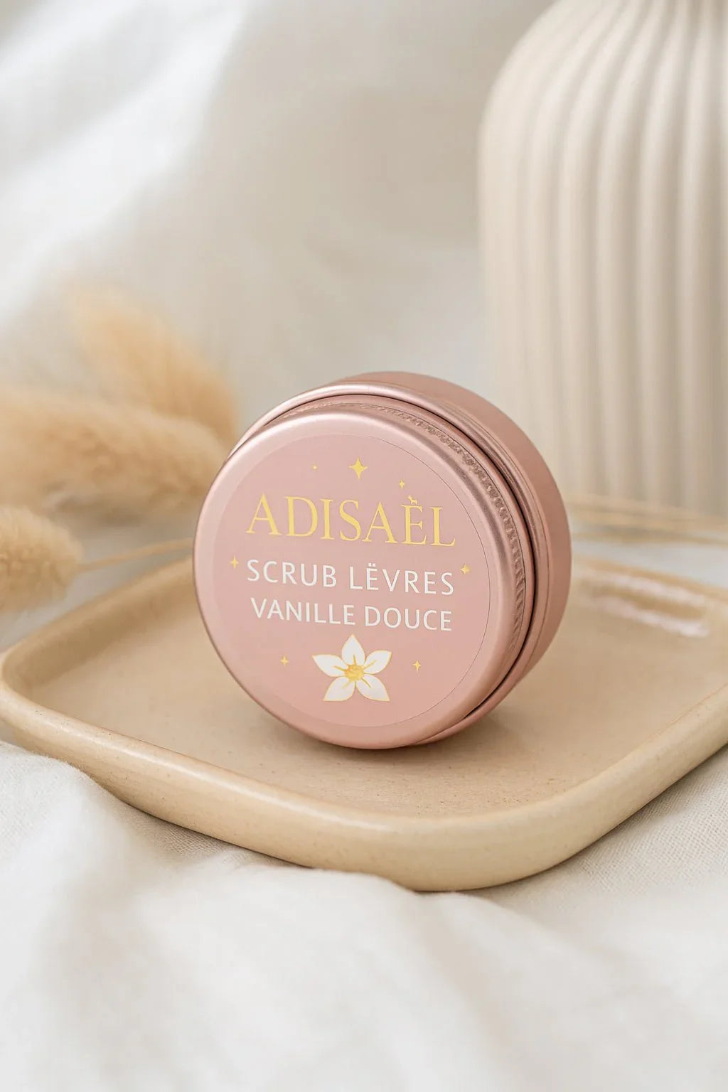 Adisael vanilla lip scrub in a pink jar on beige tray with soft white and neutral background