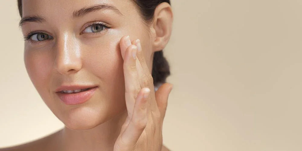 Femme appliquant un soin hydratant éclatant au visage, peau lumineuse et nette
