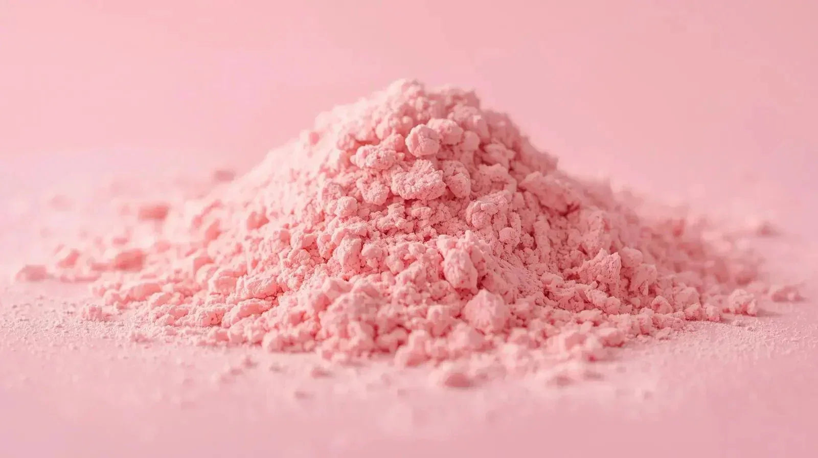Pile of fine pink collagen powder on a pink surface for skincare supplement
